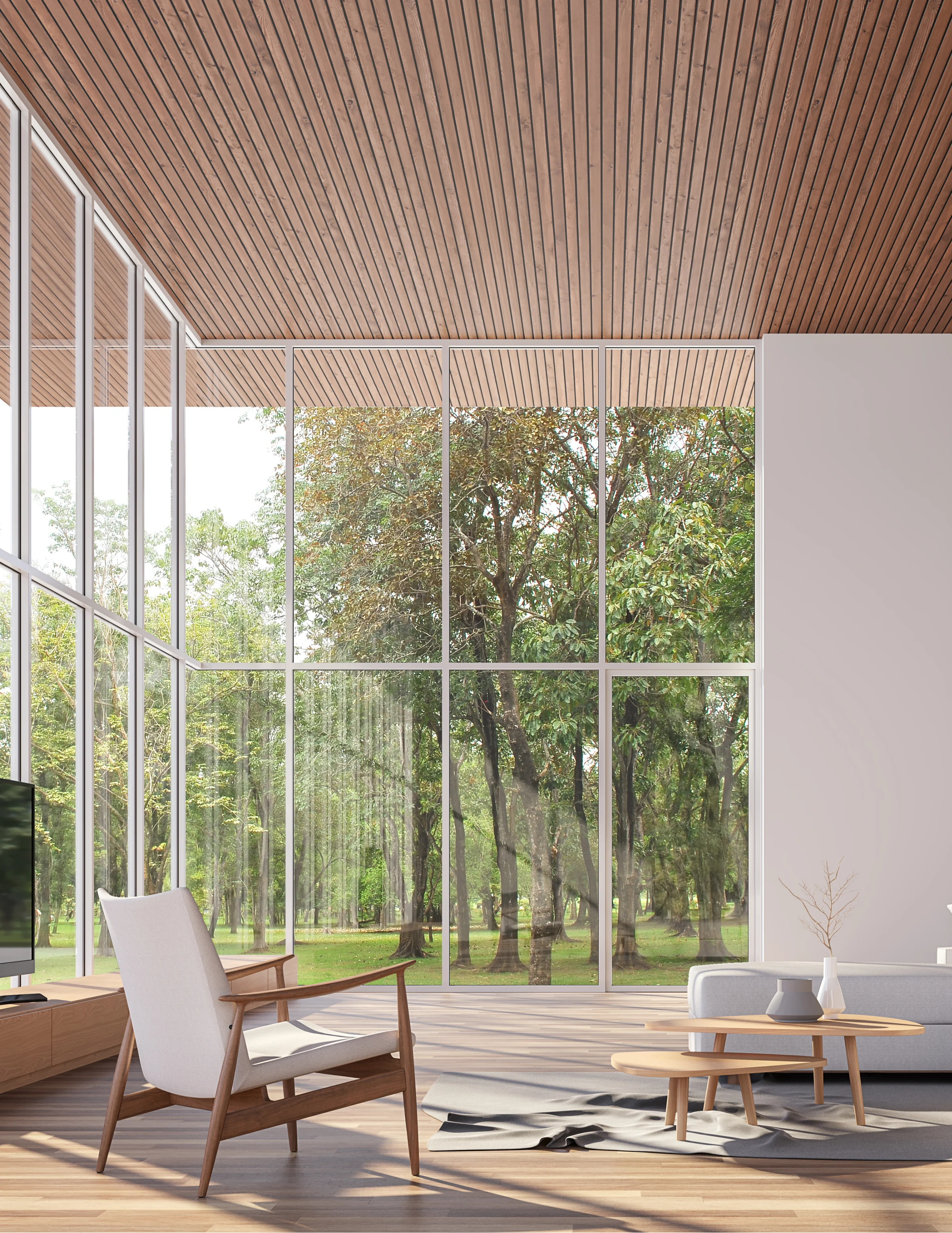 Illustrative living space with tall glass windows, a wood ceiling and views into surrounding trees.