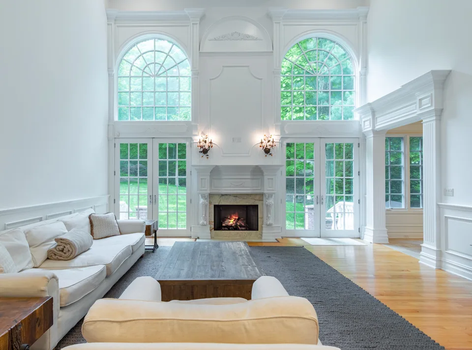 White living room with arched windows and a central fireplace
