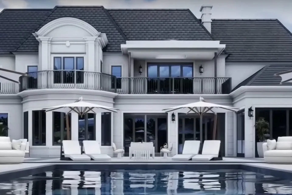 White residence and pool terrace with a dark roof and black-framed doors