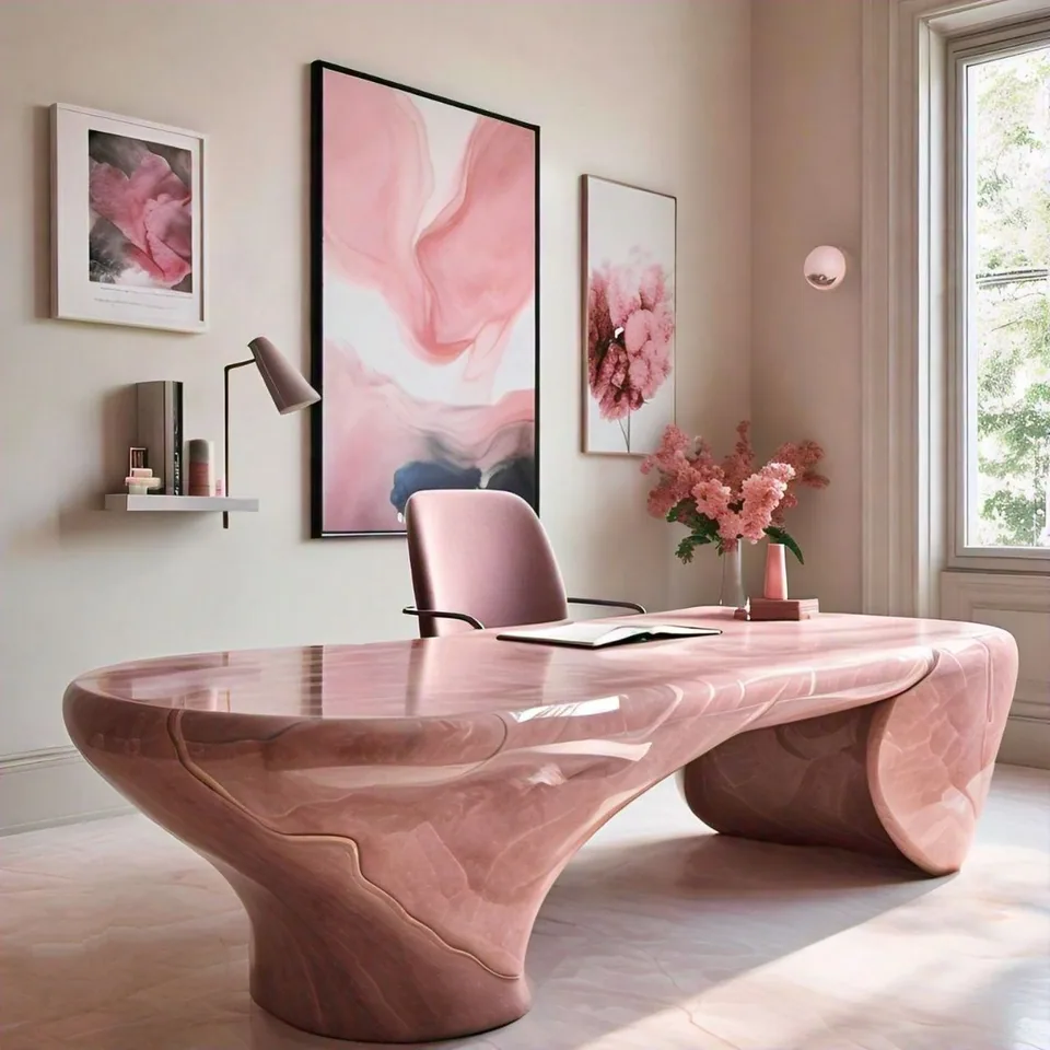 Light study with a sculptural rose-colored desk, matching chair, pink-toned artwork, flowers, and a tall window